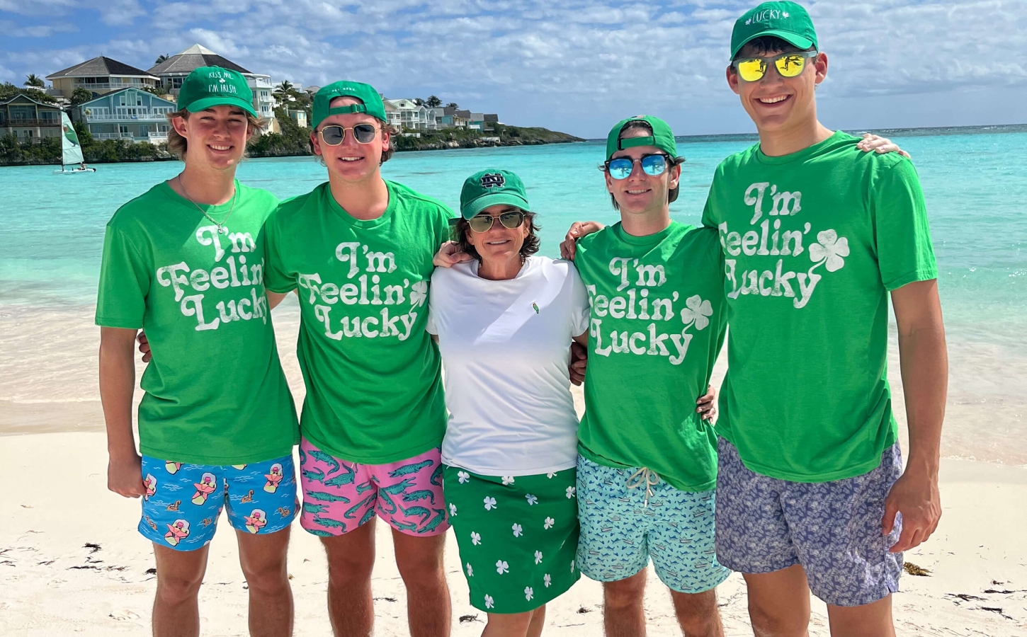 Members from The Abaco Club with green shirts with the Bahamian sea on the background