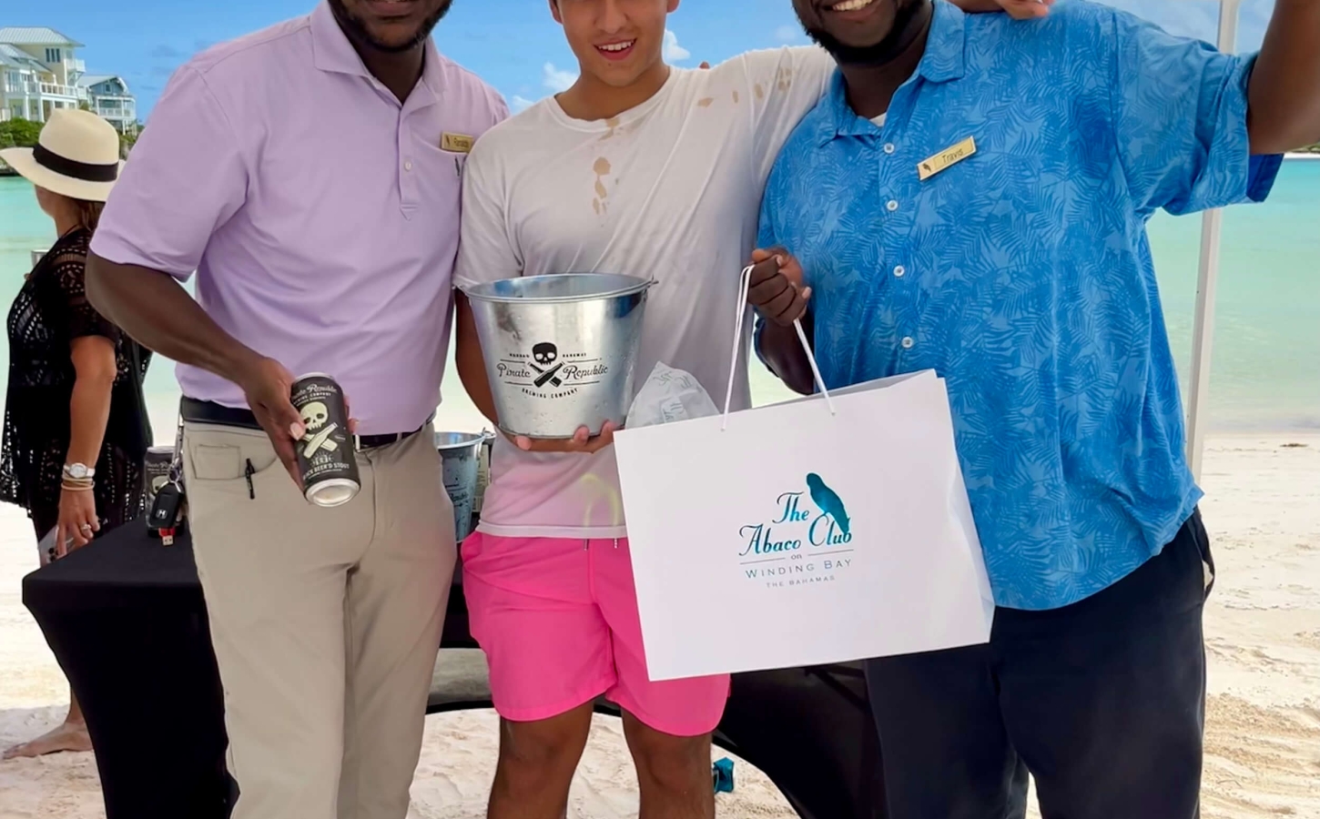 The Abaco Club staff and a Club member smiling and showcasing club community and coastal lifestyle