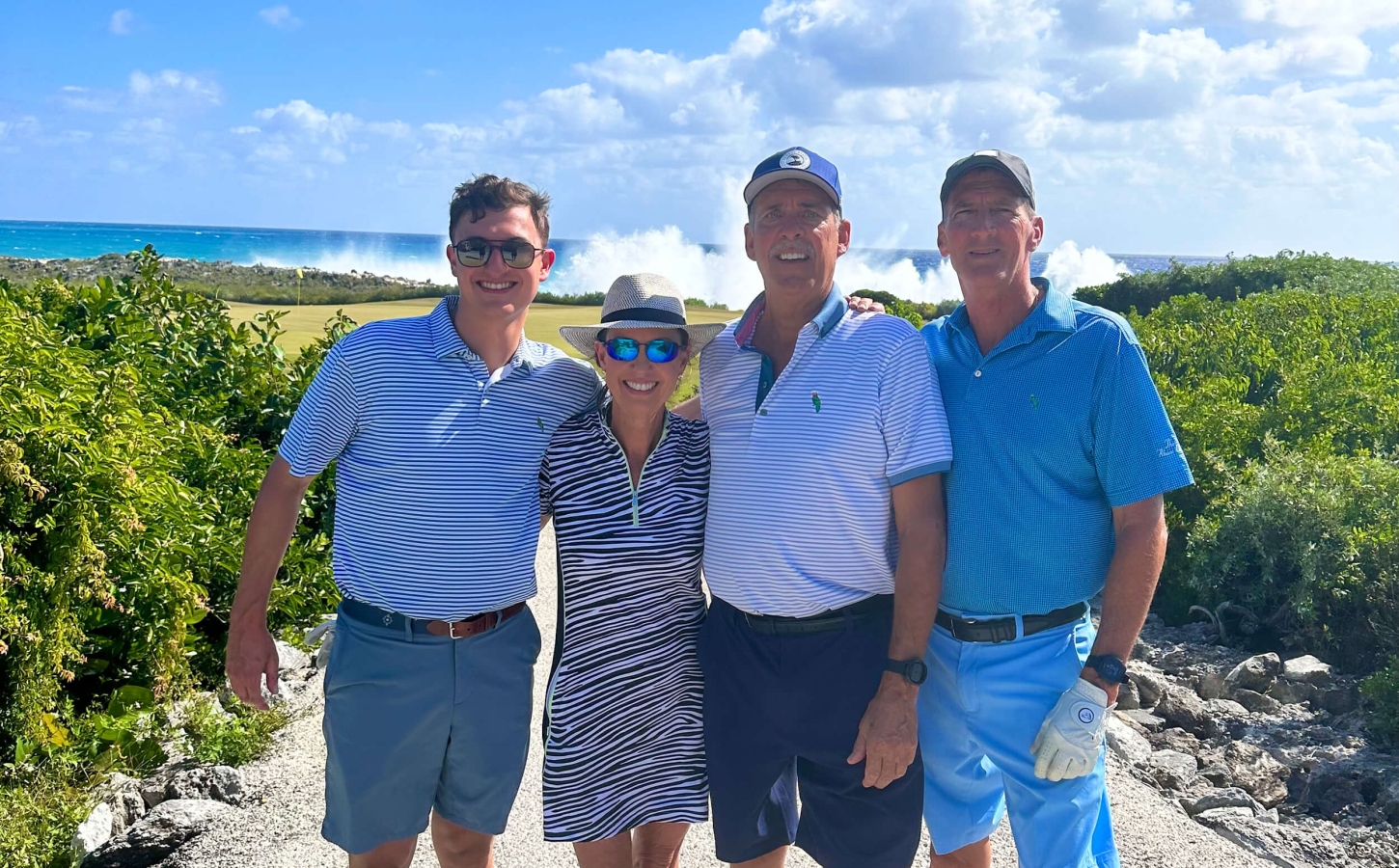 Abaco Golf Club members posing for a picture with the Bahamian sea on the background