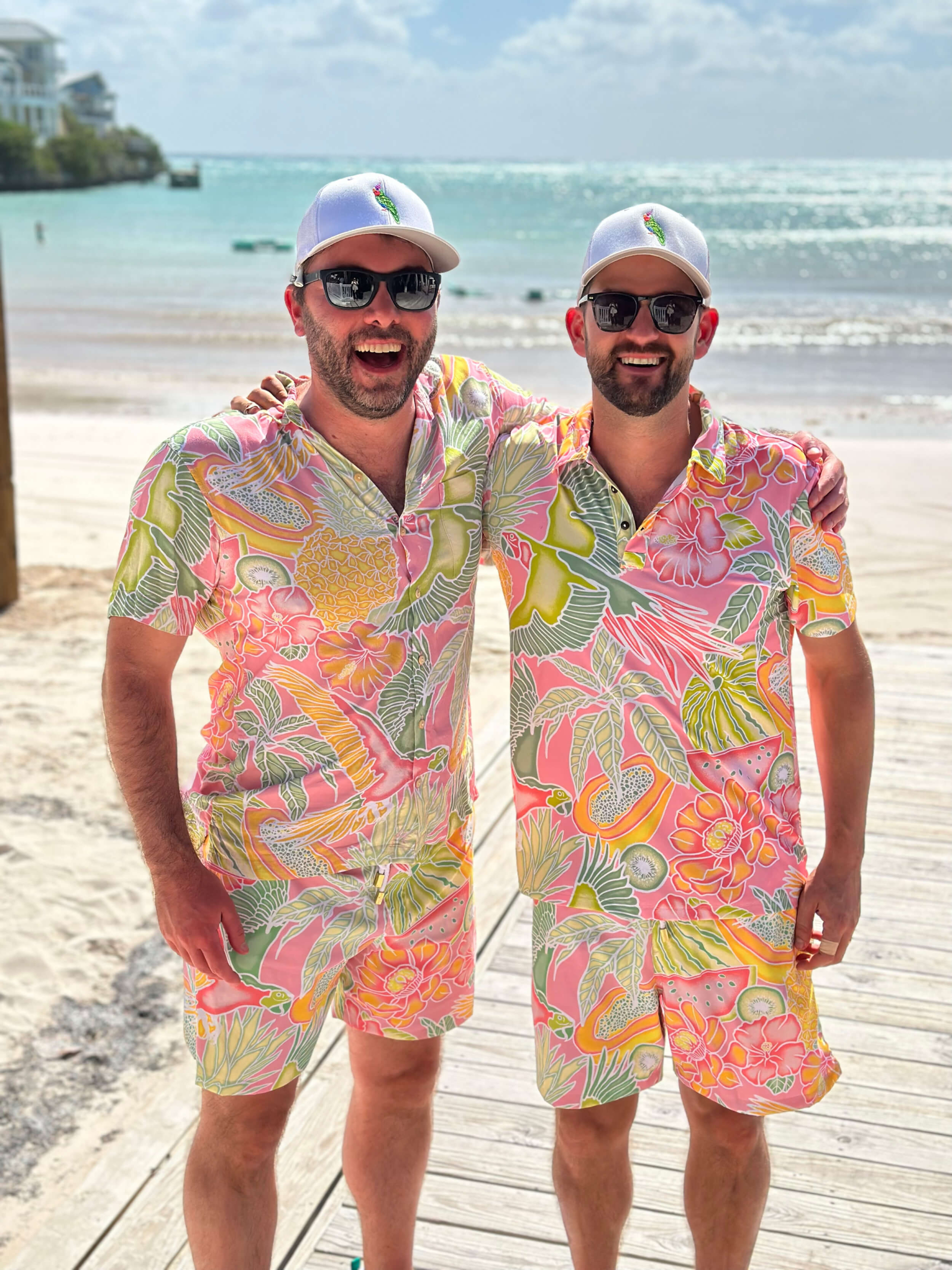 Two Abaco Club members posing and smiling with matching tropical clothes
