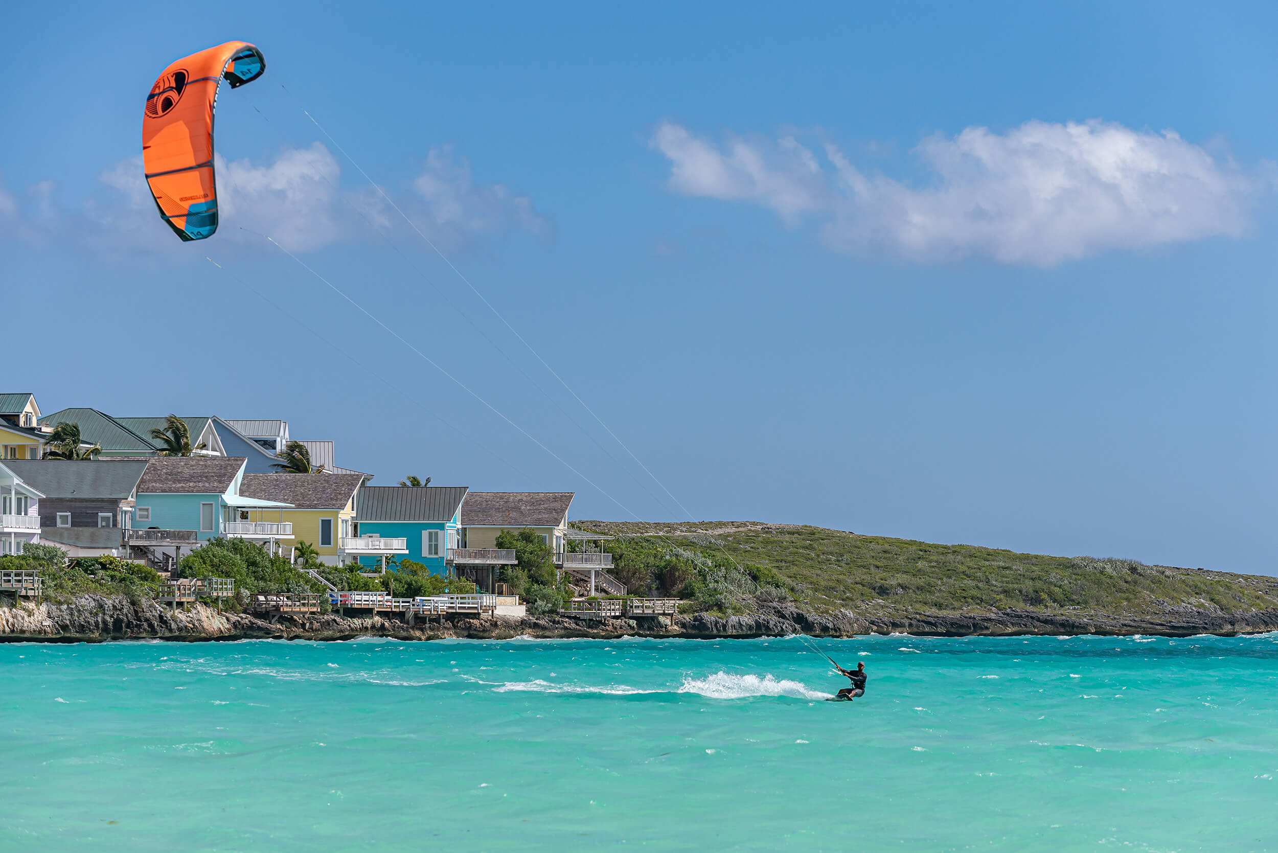 Kite surfer gliding on the blue waters near The Abaco Club's coastal living area