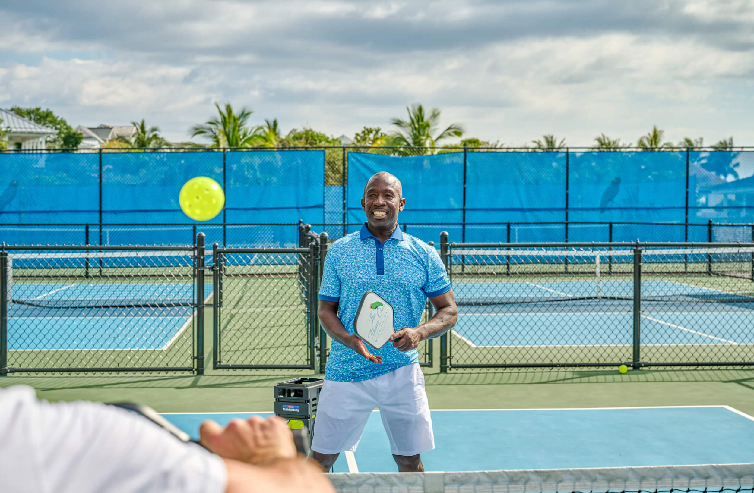 A man enjoying a game of paddle tennis at The Abaco Club's exceptional sports facilities, indicative of the club's vibrant lifestyle.