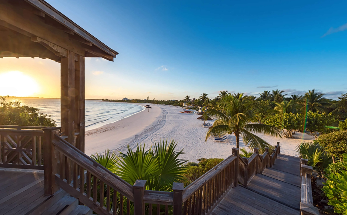 Golden sunset view from the steps leading to the beach at The Abaco Club, capturing the essence of coastal living in The Bahamas