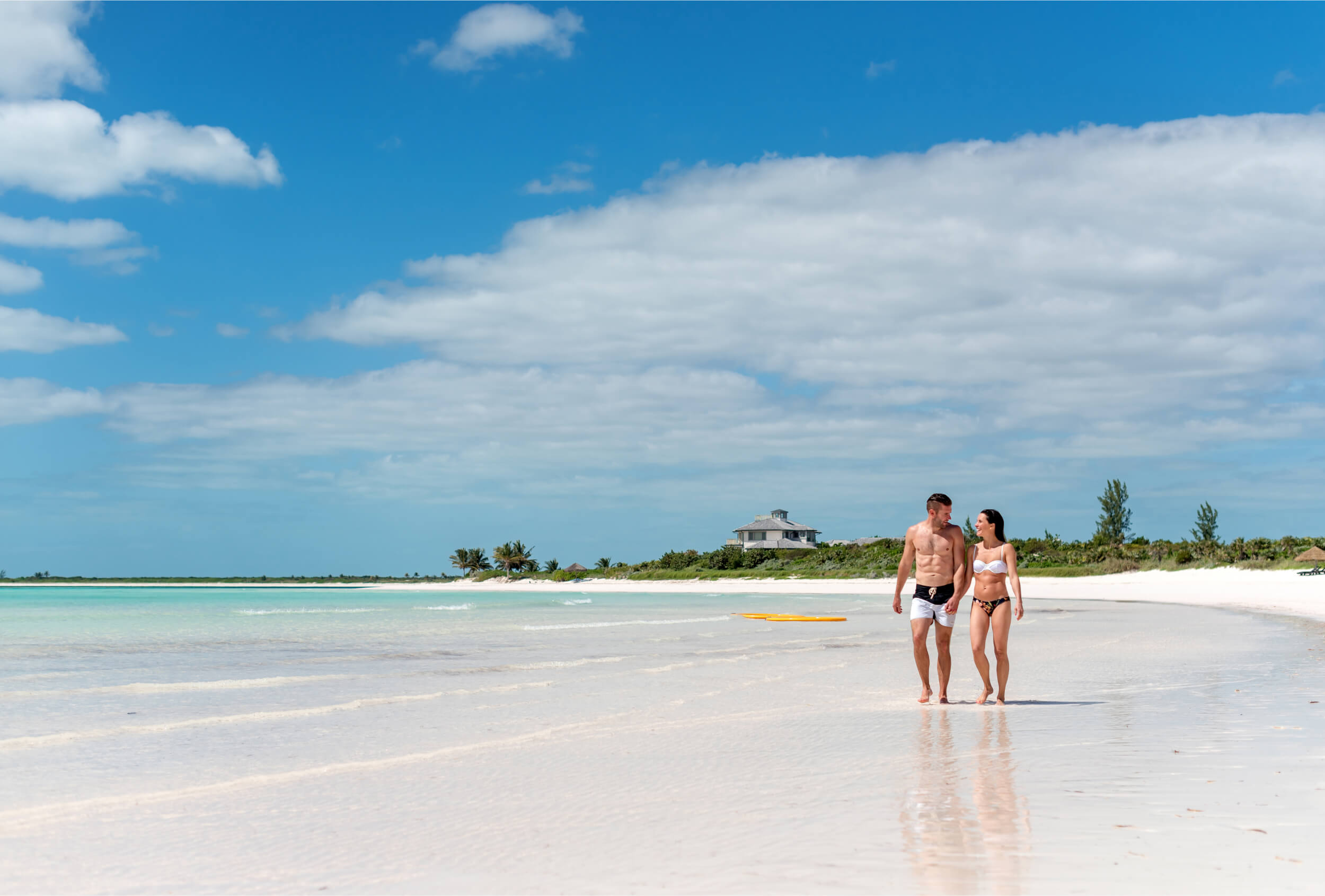 Couple enjoying The Abaco Club beach showcasing coastal lifestyle