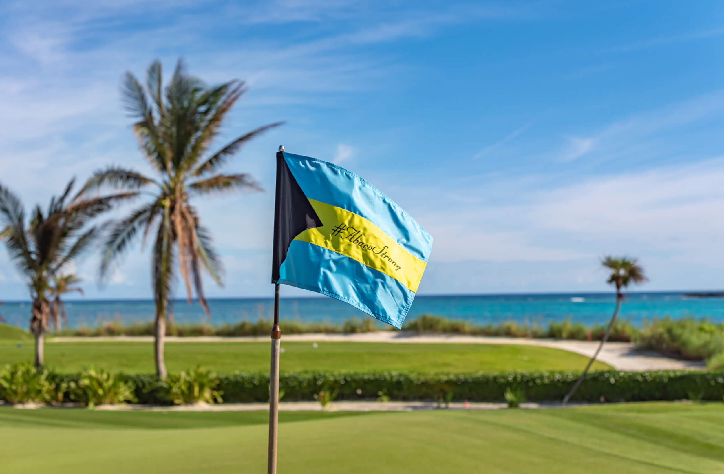 A Bahamian flag pole with the a hashtag saying Abaco strong