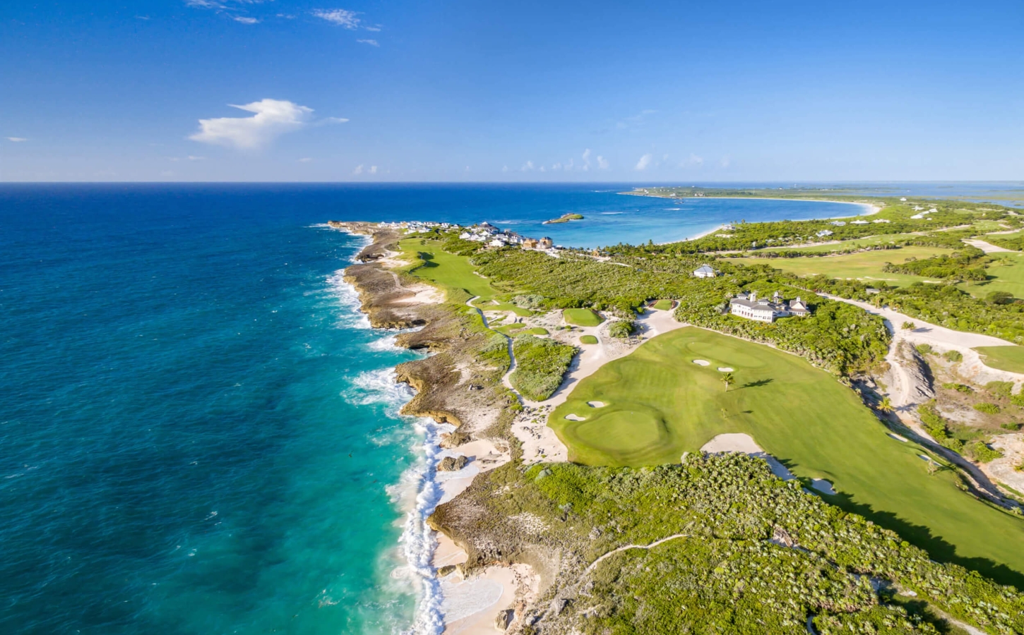 A serene aerial shot of The Abaco Club's golf club and clubhouse, a paradise of coastal club living.