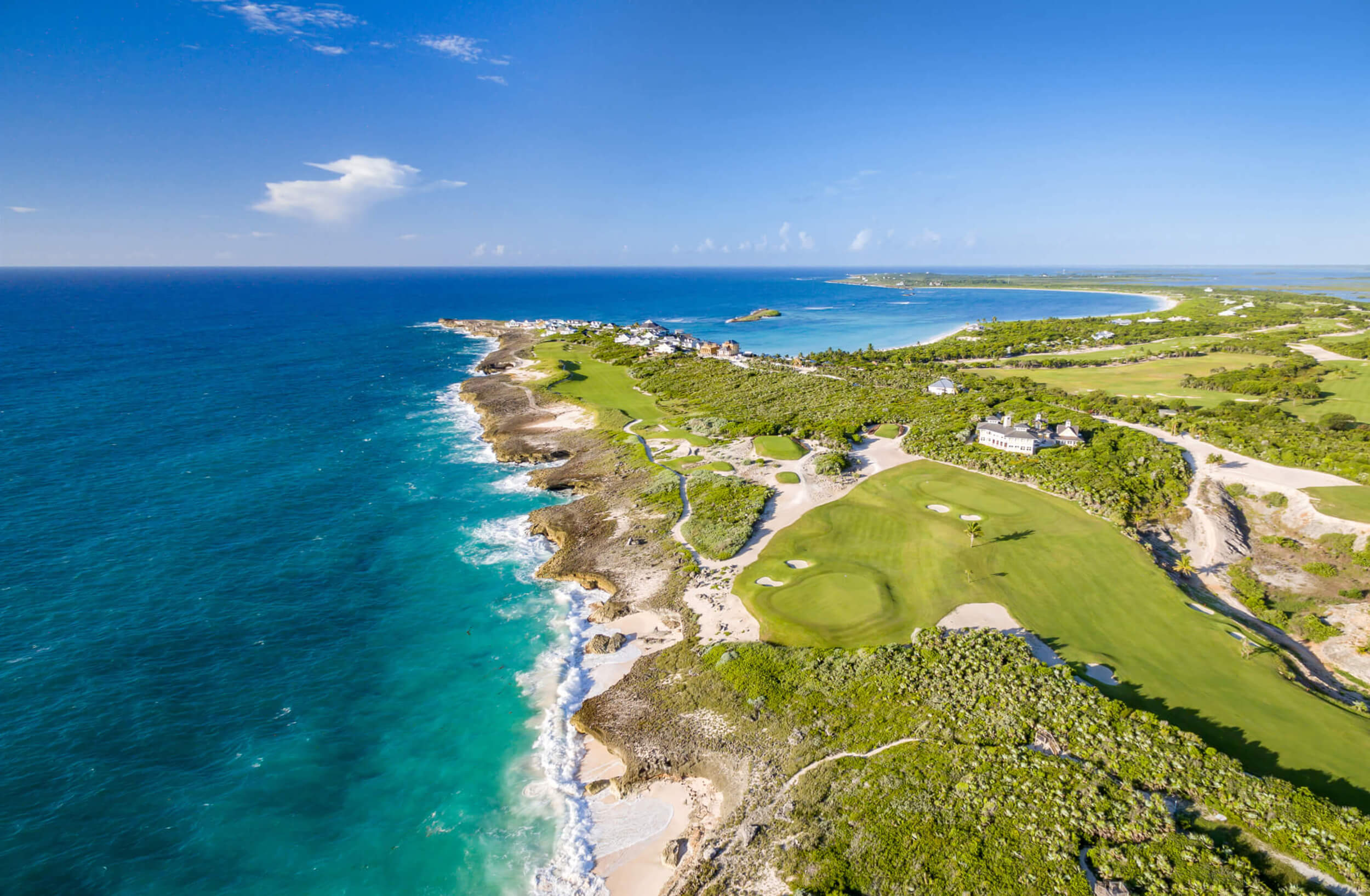 A serene aerial shot of The Abaco Club's golf club and clubhouse, a paradise of coastal club living.