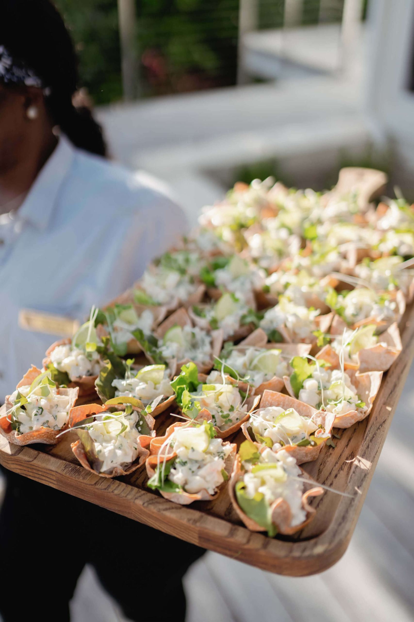 Exquisite appetizers served by a staff member at The Abaco Club, showcasing the club's high-end culinary experience in coastal living
