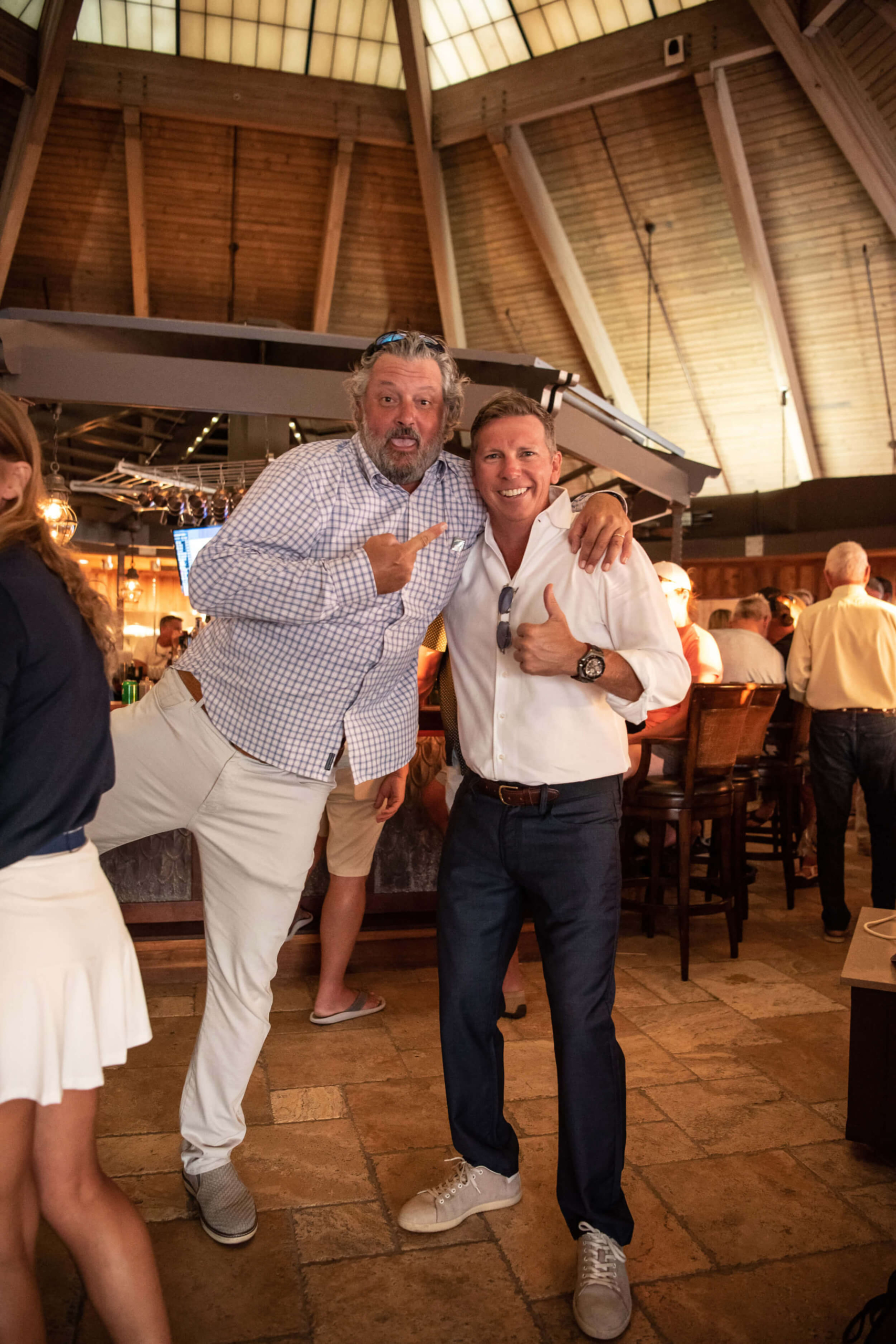 Two smiling men posing for a photo inside a restaurant in The Abaco Club