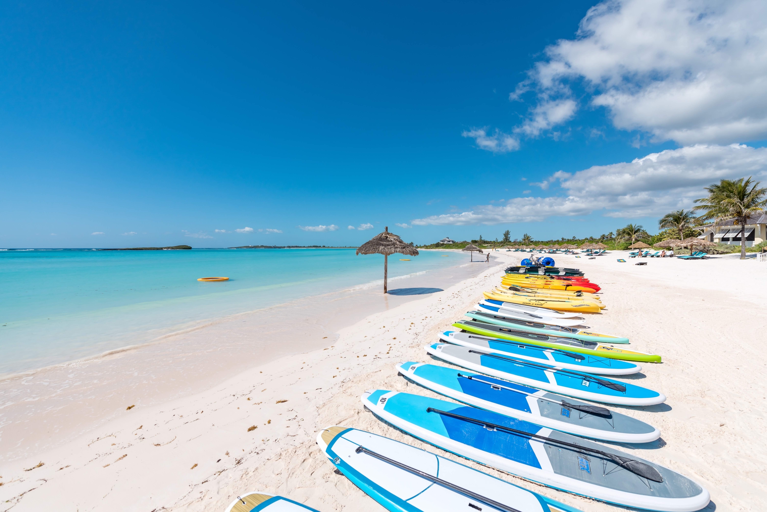 Paddleboards lined up on the beach at The Abaco Club, epitomizing coastal living