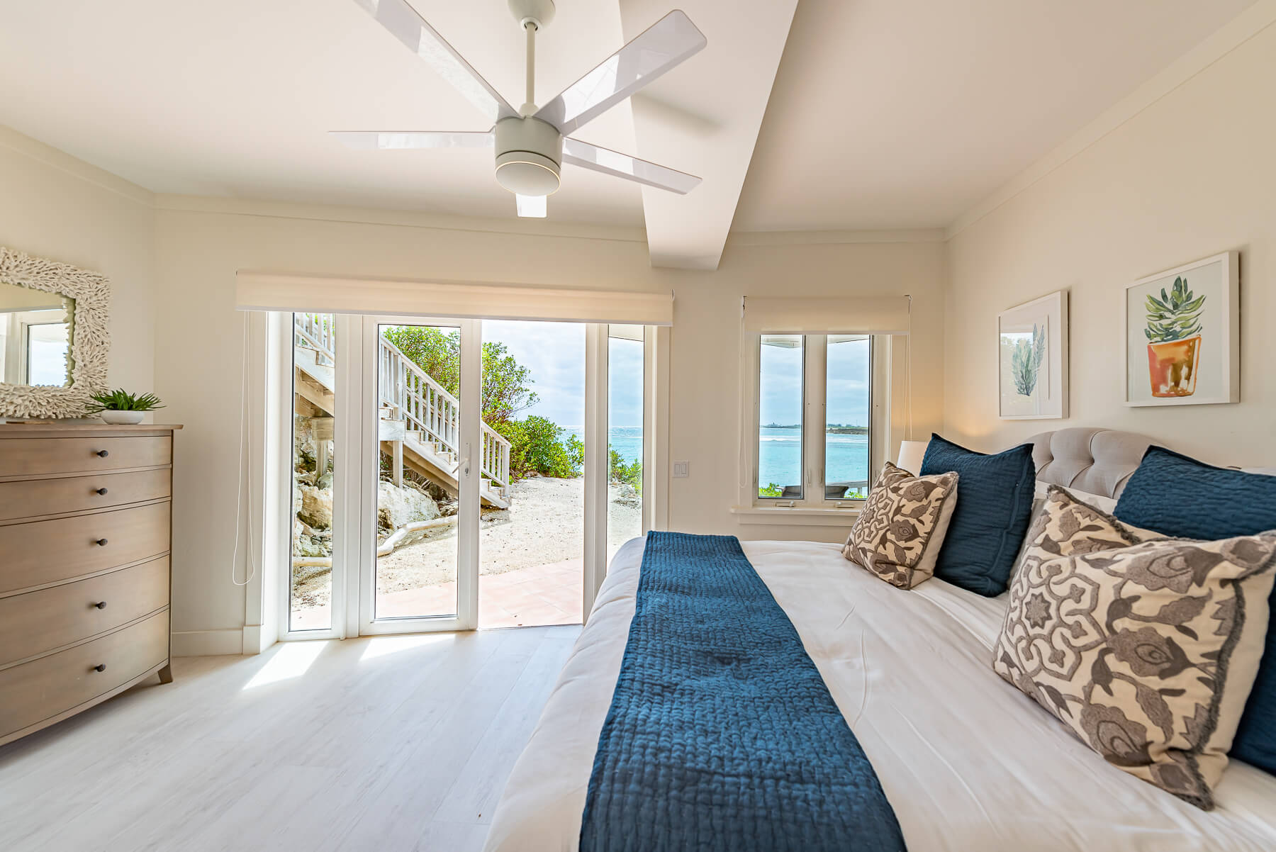 Elegant beachfront villa bedroom at The Abaco Club with access to a natural balcony overlooking the Bahamian sea.