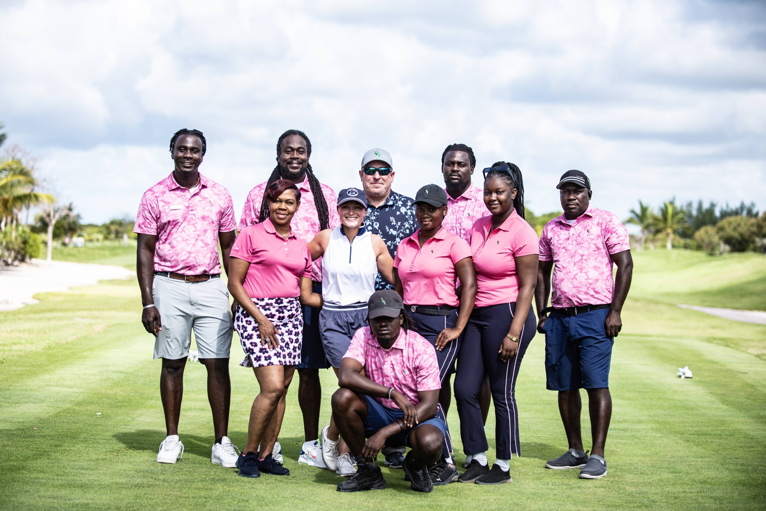 Group of The Abaco Club staff posing on the golf course, reflecting the lively spirit of coastal golf club living