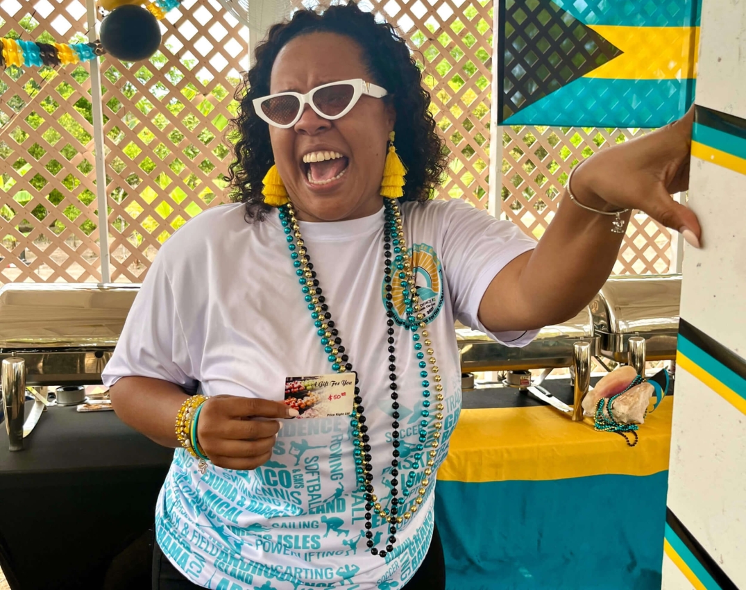 A woman cheerfully participating in a culinary event at The Abaco Club, showcasing the lively community and club lifestyle