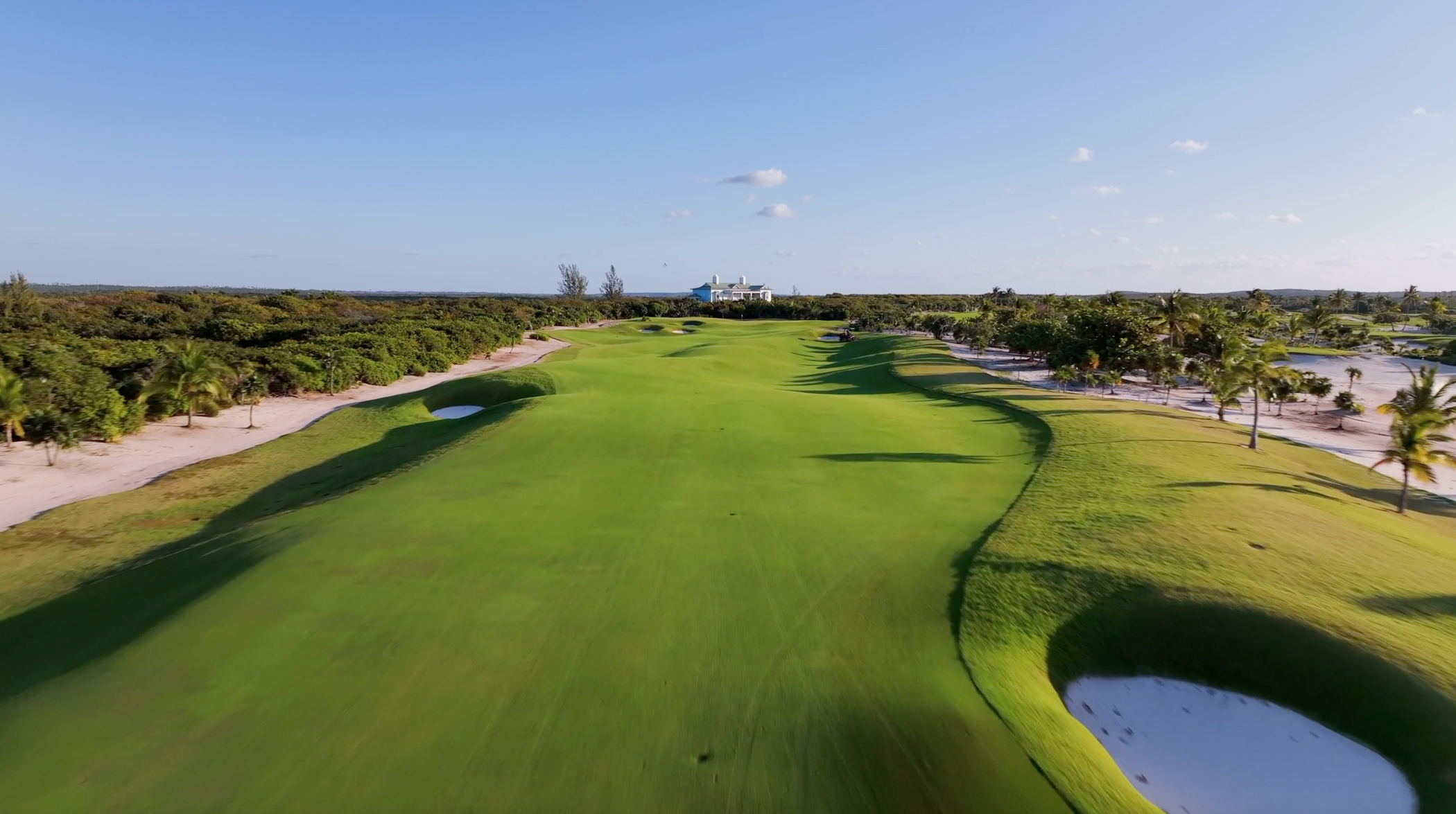 Aerial view of The Abaco Club's lush golf course adjacent to the serene Bahamian coastline, showcasing the luxury of island golfing