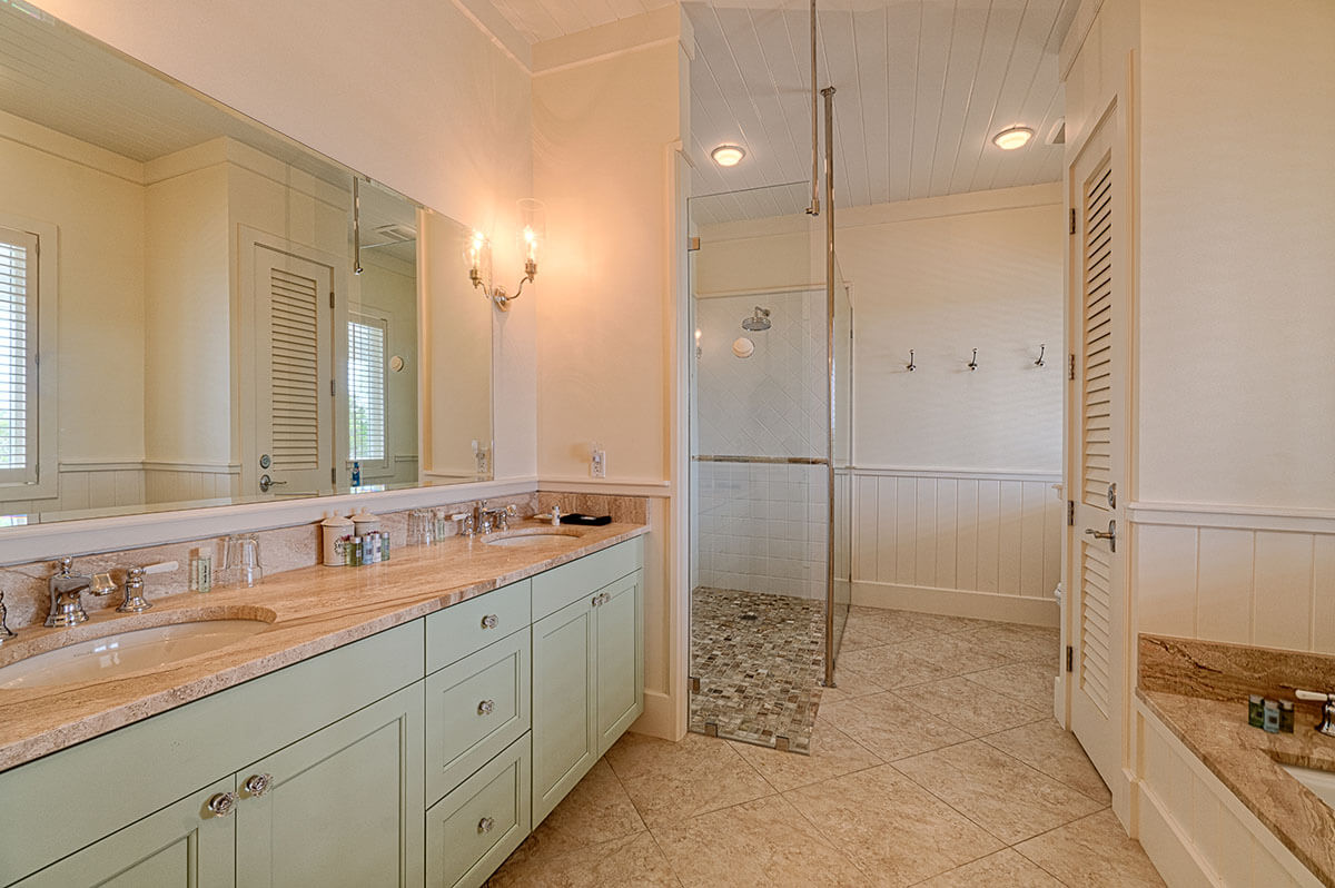 Elegant bathroom interior at The Abaco Club featuring dual vanities and a spacious walk-in shower, reflecting the upscale coastal living in the Bahamas