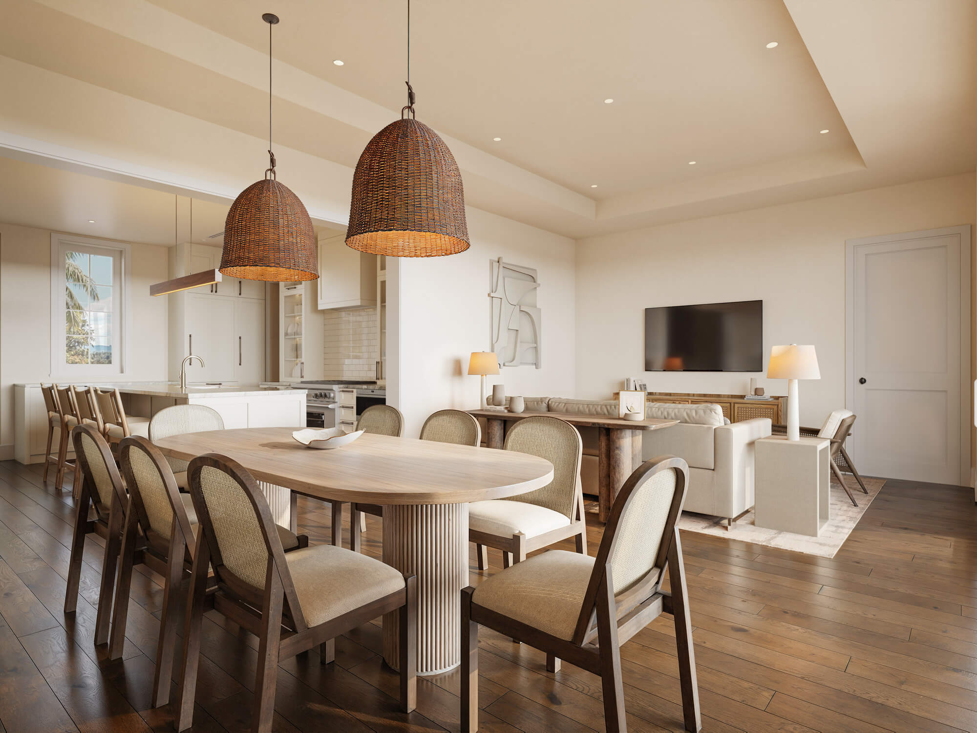 Open-concept dining area with a large wooden table and wicker chairs, two woven pendant lights, and a visible kitchen in the background.